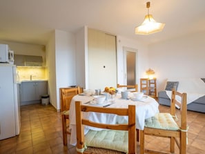 A compact living space with a dining area, kitchenette, and a cozy seating area.