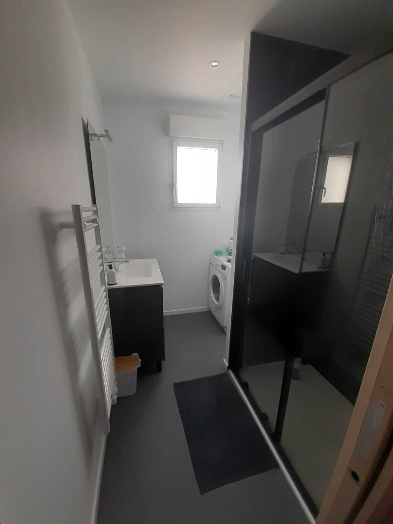 Un baño pequeño con lavamanos, espejo y lavadora.