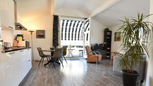 Un espacio habitable moderno con comedor, cocina y un ventanal grande.