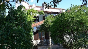 A rustic building with a stone facade, a tiled roof, and a small patio area with outdoor furniture.