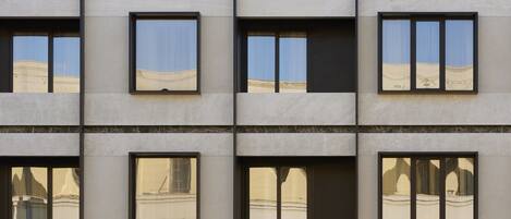 Un edificio de varios pisos con una fachada de ventanas y balcones.