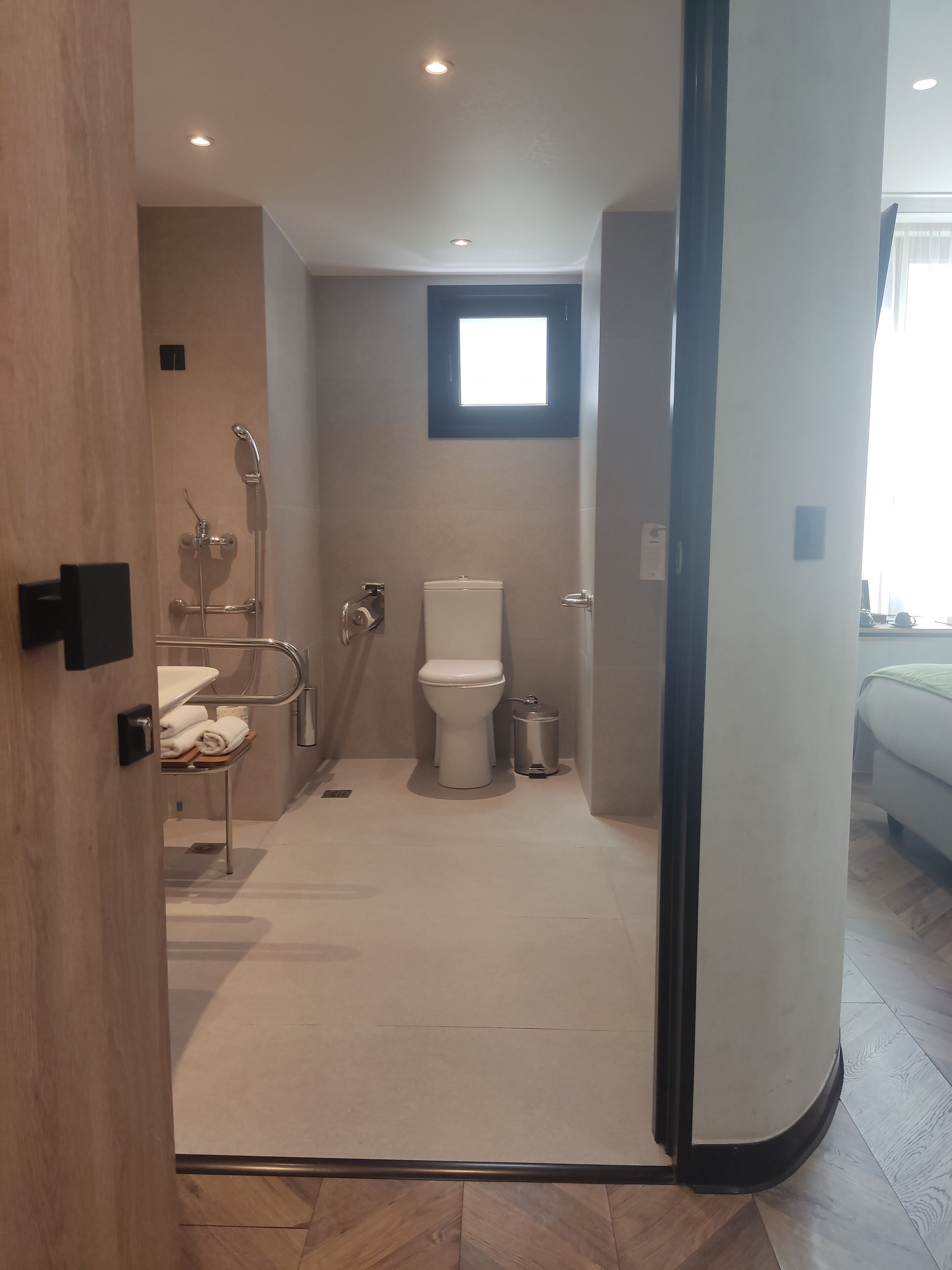 A modern bathroom with a shower, toilet, and sink.