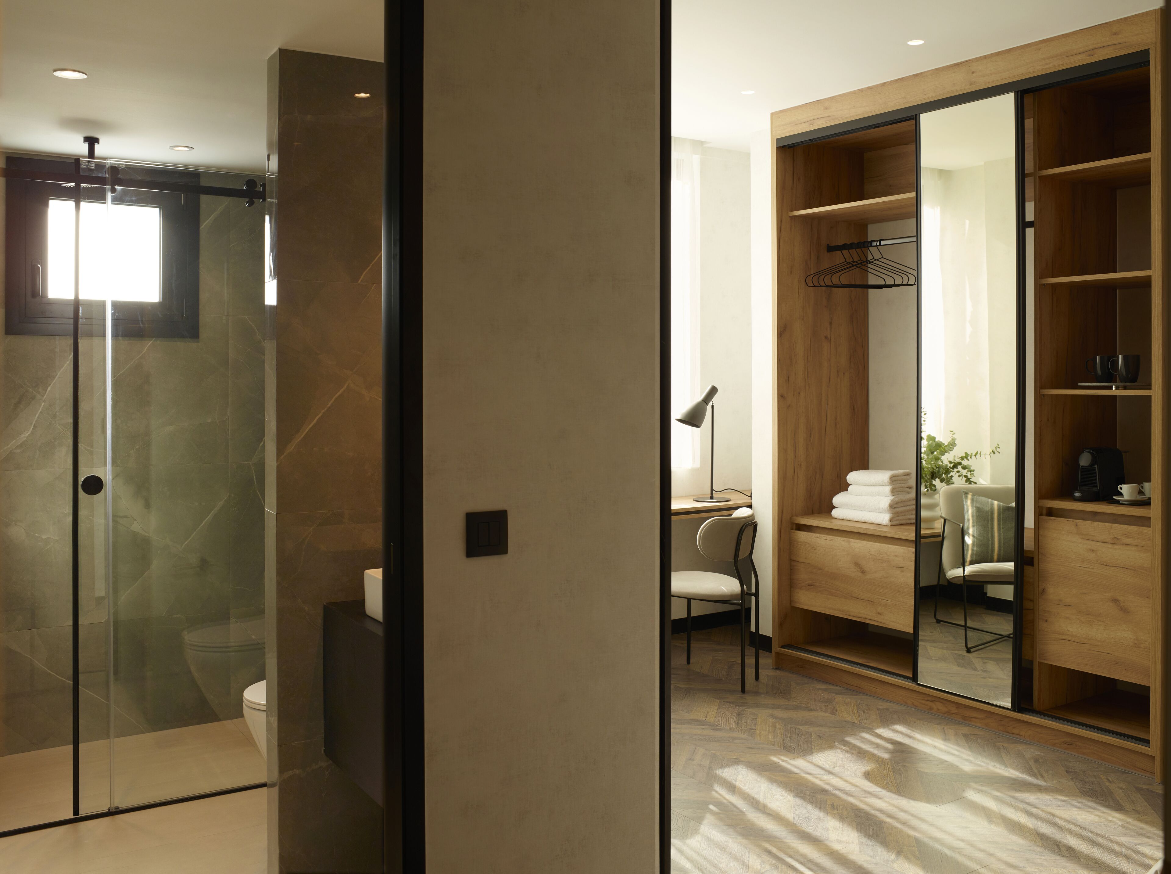 Un baño moderno con cabina de ducha de vidrio, inodoro y tocador con espejo.