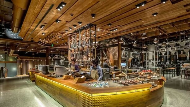 Cocina moderna con detalles de madera, electrodomésticos de acero inoxidable y una isla central con alimentos.
