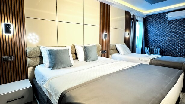 A modern bedroom with a large bed, bedside tables, and a built-in wardrobe. - Amara Old City Hotel & Spa (Istanbul)
