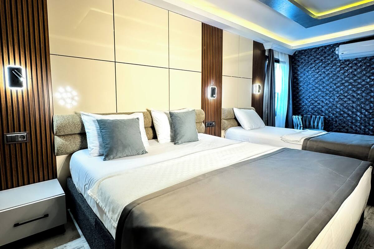 A modern bedroom with a large bed, bedside tables, and a built-in wardrobe.