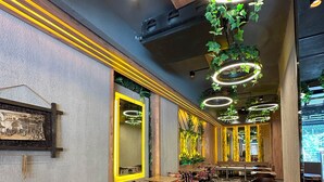 A spacious restaurant with long communal tables, colorful patterned chairs, and decorative ceiling lights. - Amara Old City Hotel & Spa (Istanbul)
