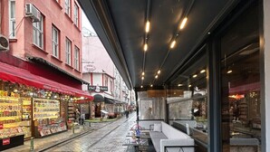 A cafe with outdoor seating, a red awning, and a cobblestone street. - Amara Old City Hotel & Spa (Istanbul)