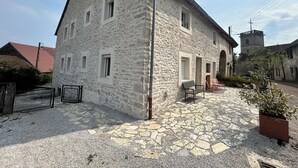 A stone building with multiple windows and a small balcony.