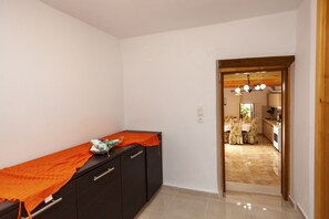 A hallway leading to a dining area with a table set for two. - Kentrochori Mountain View House (Κεντροχώρι)