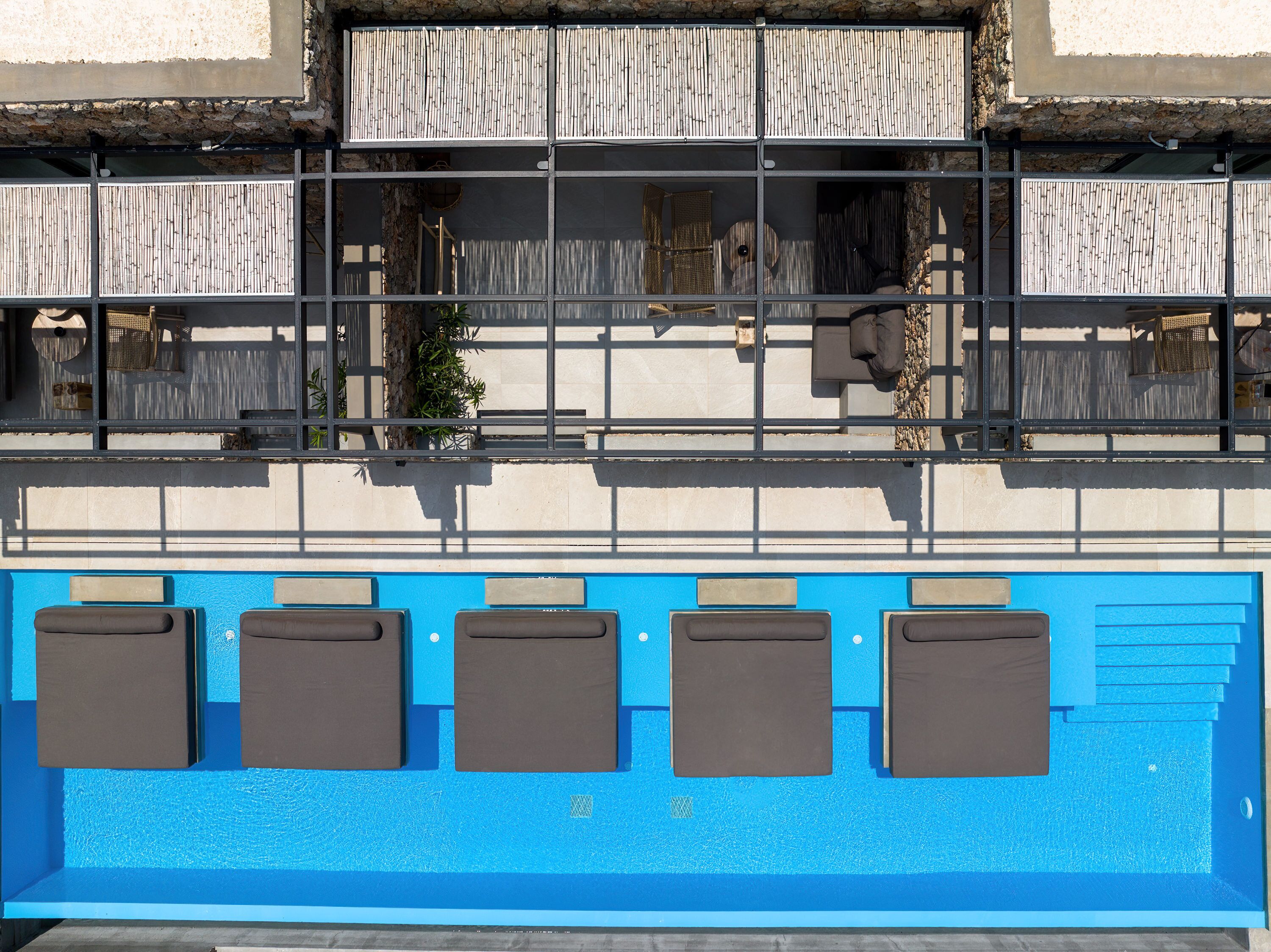 Un área de piscina con seis tumbonas y una piscina azul.