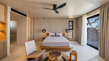 Un dormitorio moderno con una cama grande, ventilador de techo y vistas al exterior.