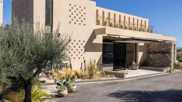 A modern building with a flat roof, a covered entrance, and a stone facade.