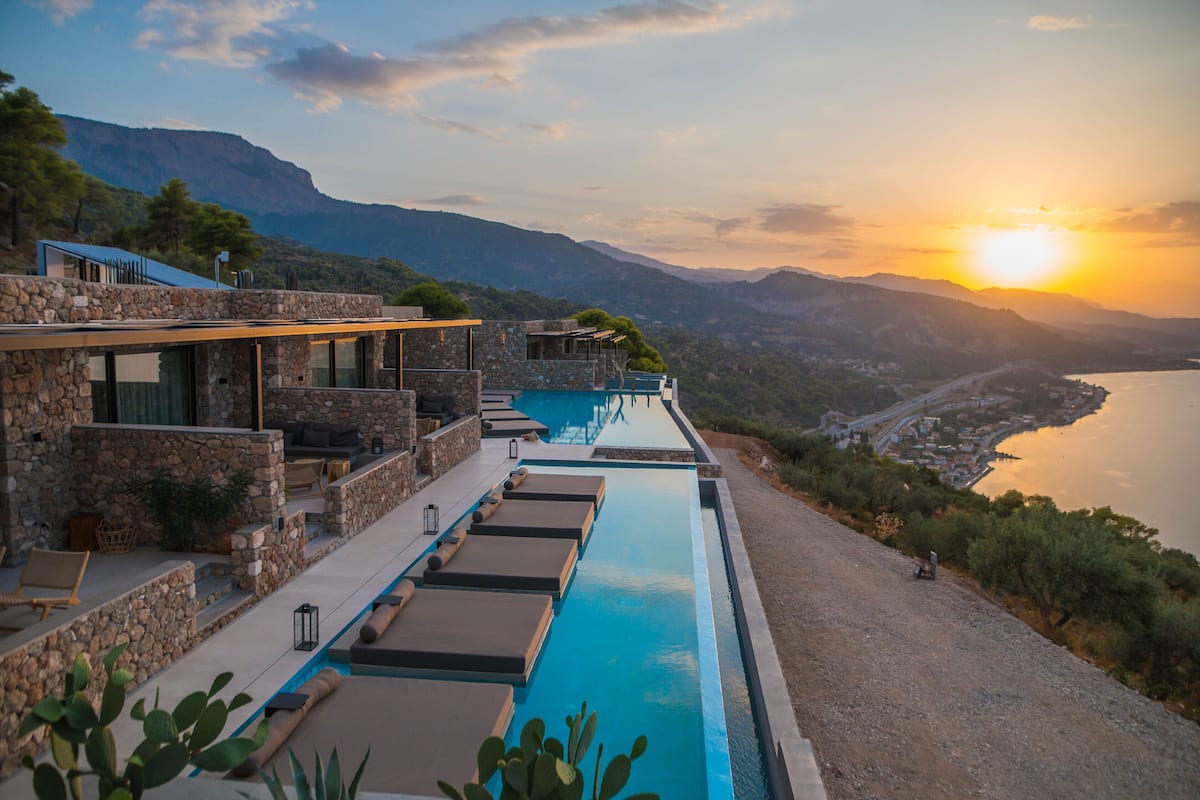 Una piscina infinita moderna con vistas al mar y a las montañas.
