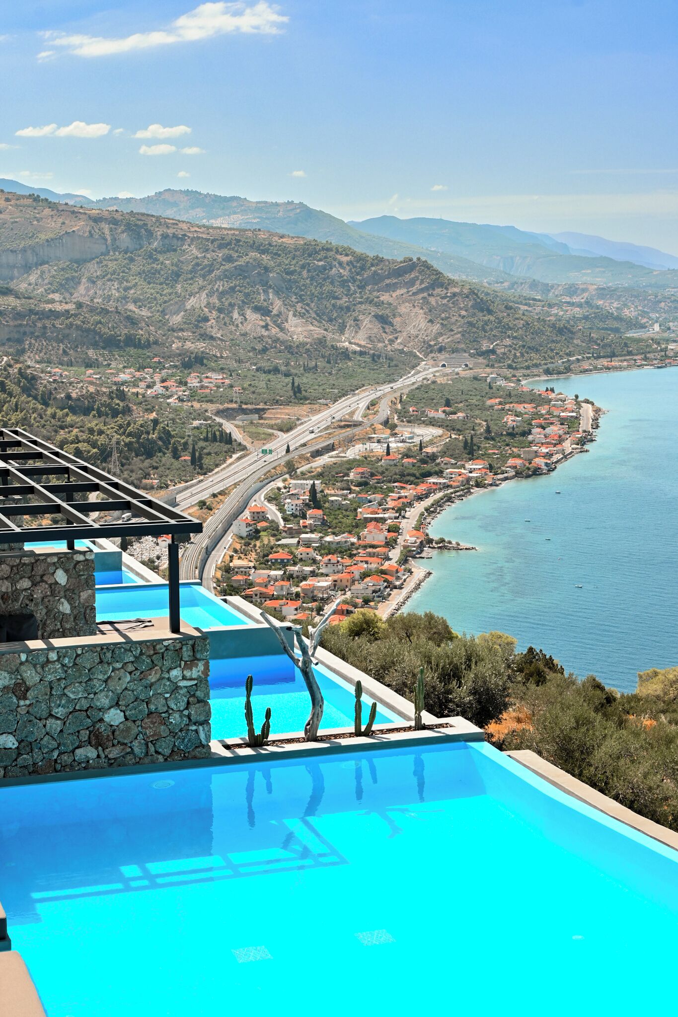 Una piscina con vista a un pueblo costero y montañas.