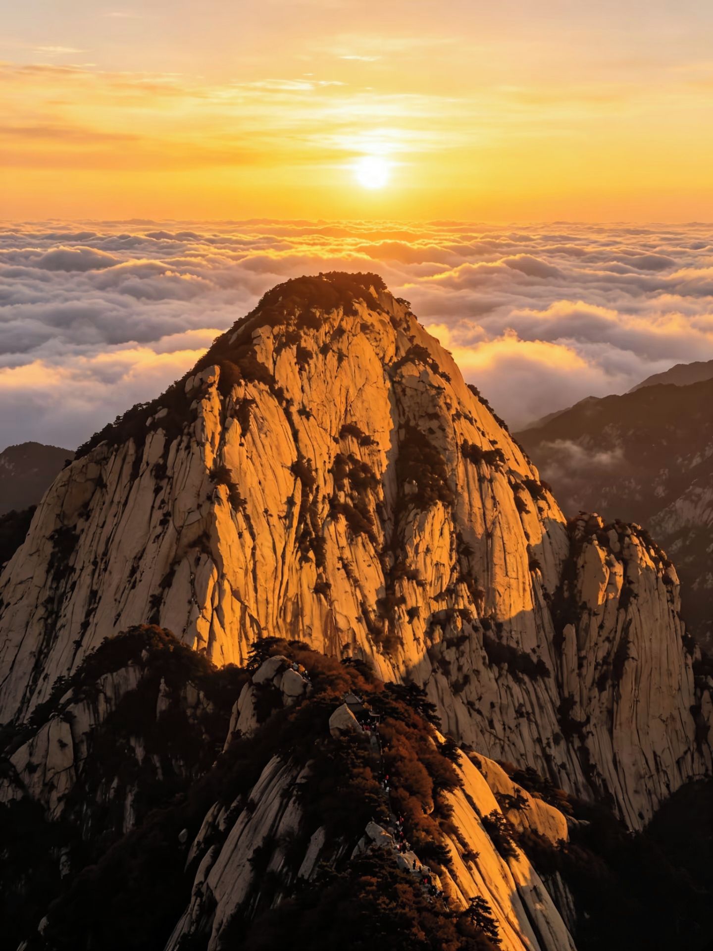 A mountain peak with a clear sky and clouds below.