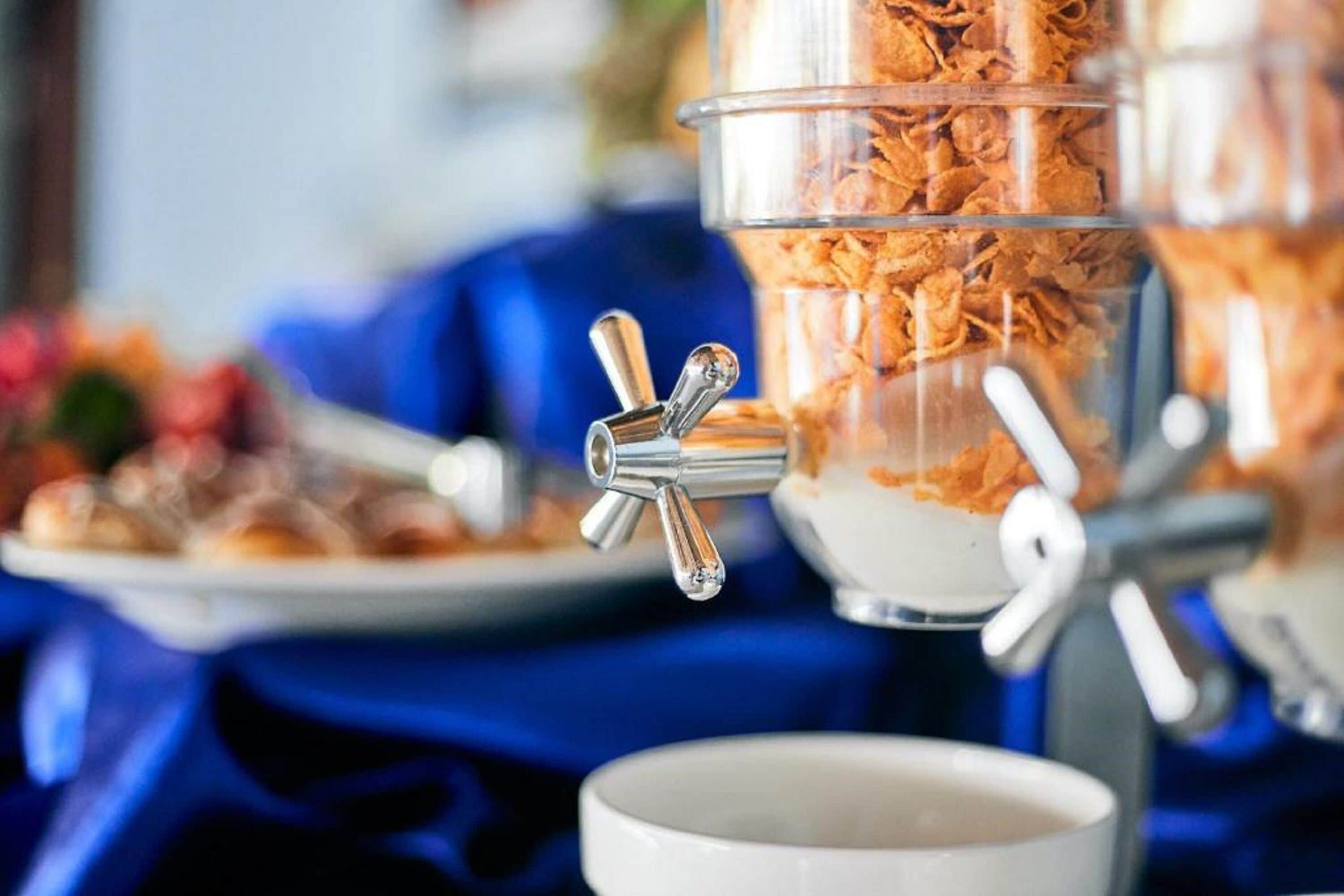 A breakfast buffet with a cereal dispenser.