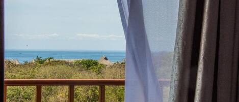 A balcony with a view of the ocean and beach.