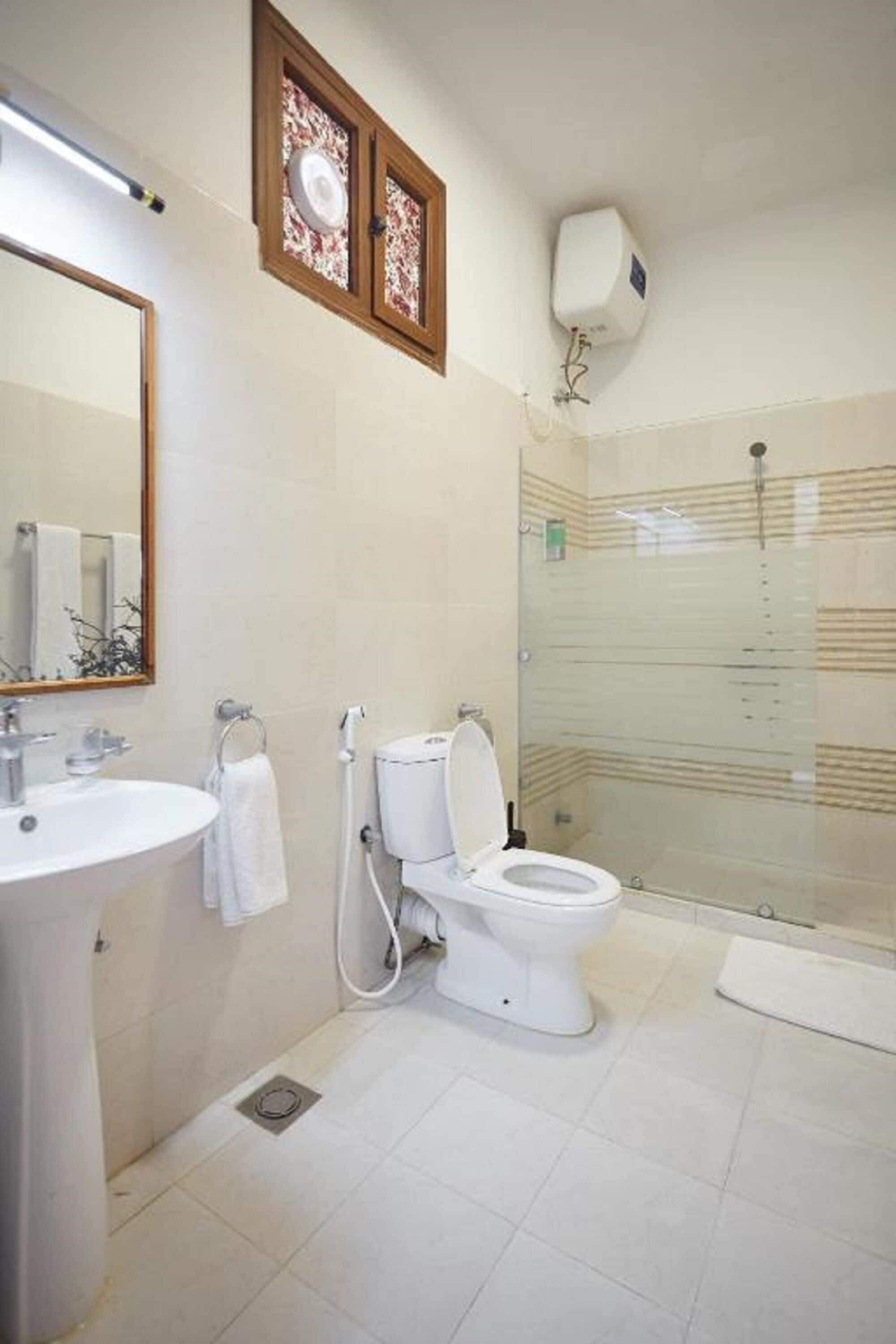A bathroom with a toilet, sink, and shower.
