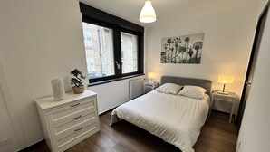 A bedroom with a bed, bedside tables, a dresser, a window, and a wall art piece. - High comfort accommodation | Le Puy en Velay (Le Puy-en-Velay)