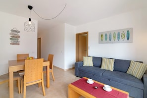 Una sala moderna con comedor, un conjunto de sofá y una obra de arte en la pared.