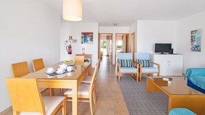 Une chambre d’hôtel moderne comprenant un coin repas, un salon et un téléviseur.