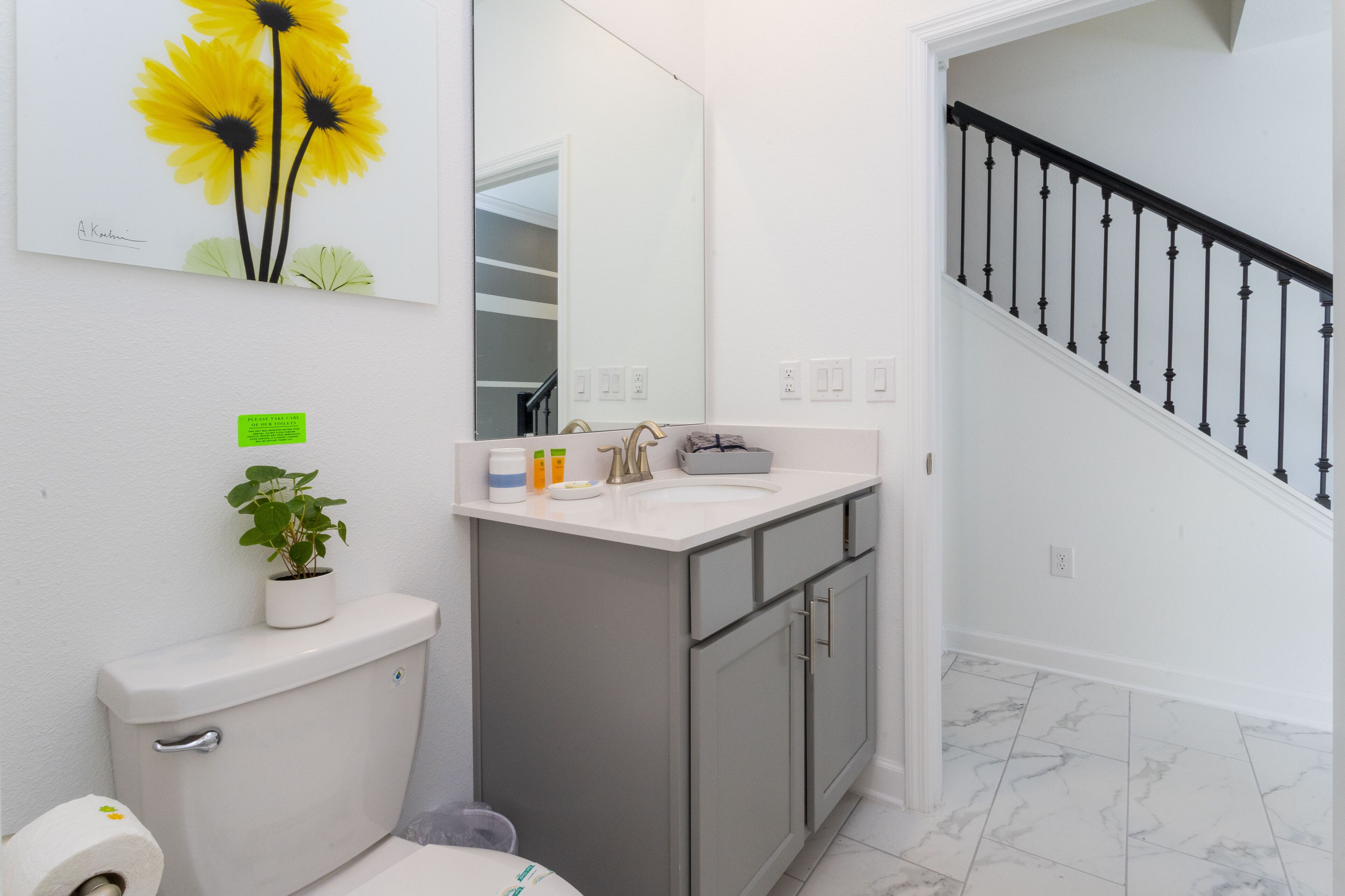 Un bagno moderno con WC, lavabo e specchio.