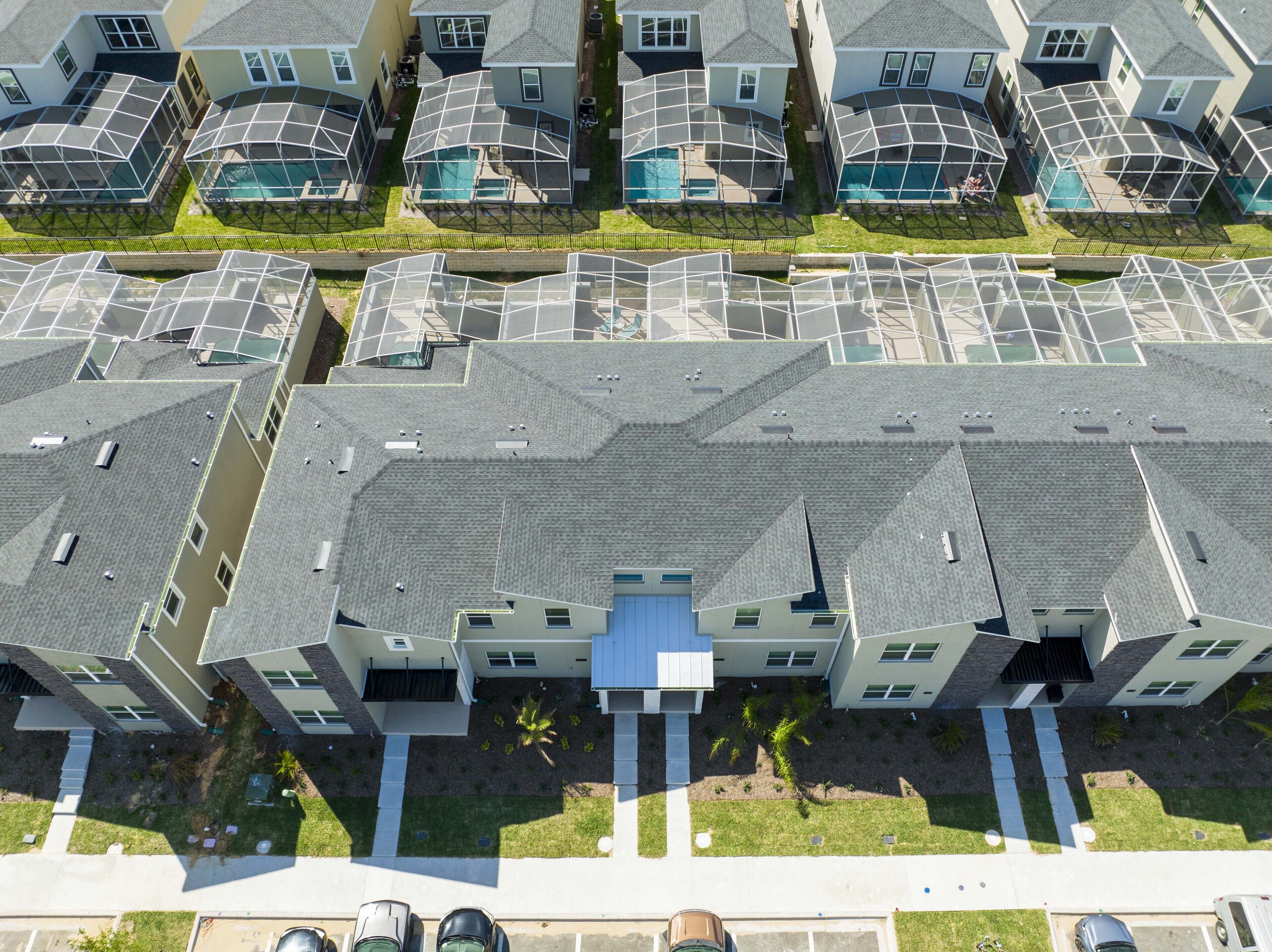 A high-rise residential building with multiple balconies, a central courtyard, and a swimming pool.