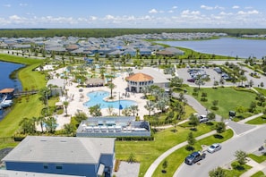 A resort with a central pool, multiple buildings, and a lake. - Gorgeous 3Bd 8 Guests @Storey Lake Resort Close to Disney 101 3191 (Kissimmee)
