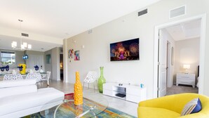 A modern living room with a glass coffee table, a yellow sofa, and a colorful rug. - Family Friendly 2 Bd Close to Disney @ Storey Lake 105 3161 (Kissimmee)