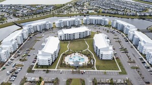 A modern residential complex with a central swimming pool, arranged in a circular layout with multiple apartment buildings. - Family Friendly 2 Bd Close to Disney @ Storey Lake 105 3161 (Kissimmee)