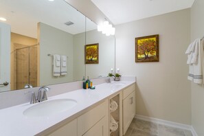 A modern bathroom with two sinks, a large mirror, and two framed paintings. - Stunning 2Bd Apto Close to Disney @ Storey Lake 105 3171 (Kissimmee)