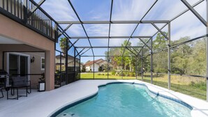 Una piscina con vista despejada al vecindario circundante, incluyendo casas y áreas verdes.