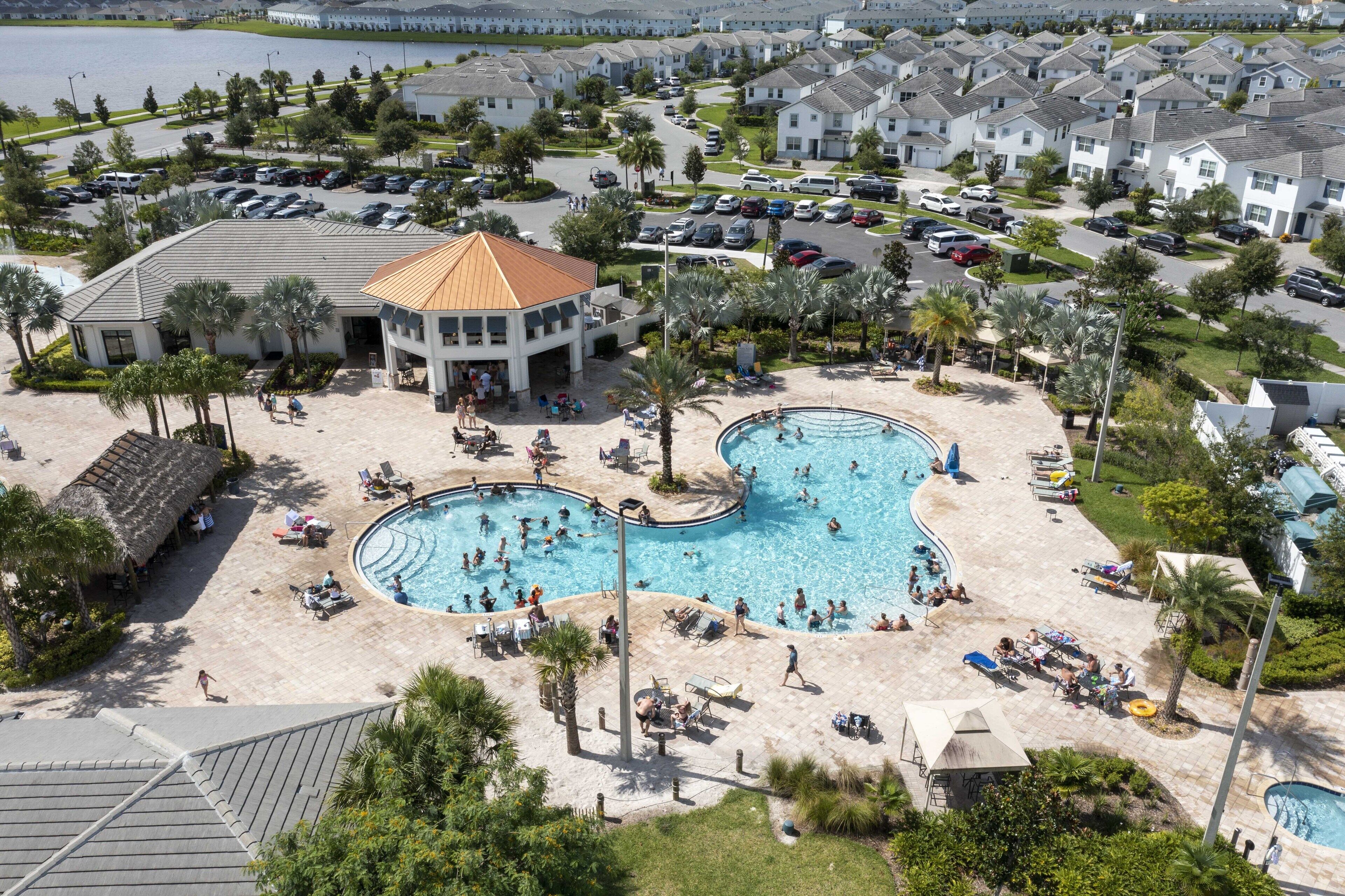Ein Resort mit mehreren Swimmingpools, einer Strandanlage und einem Parkplatz.