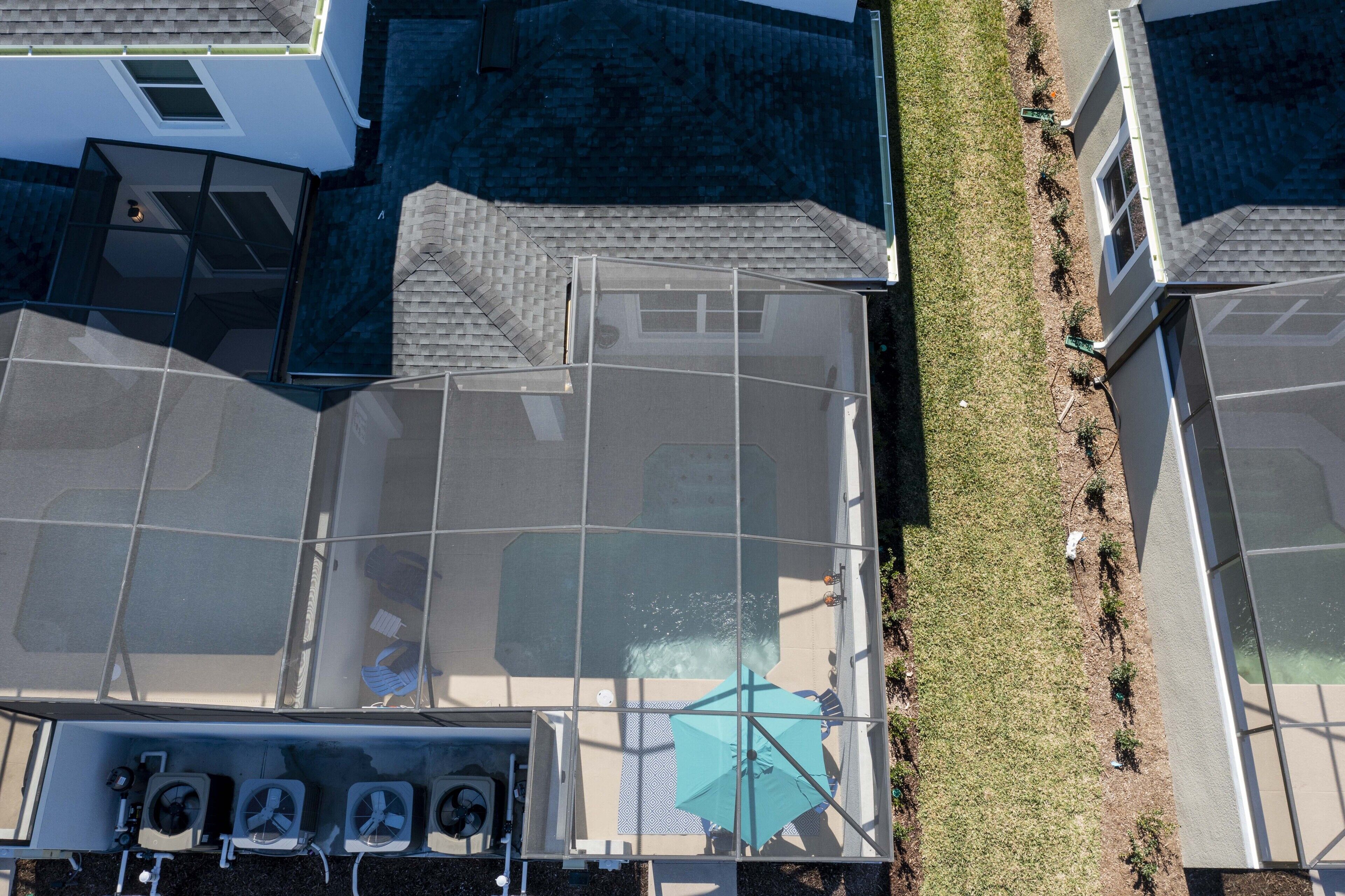 Eine Dachterrasse mit Glasveranda, einem kleinen Pool und einer Rasenfläche.