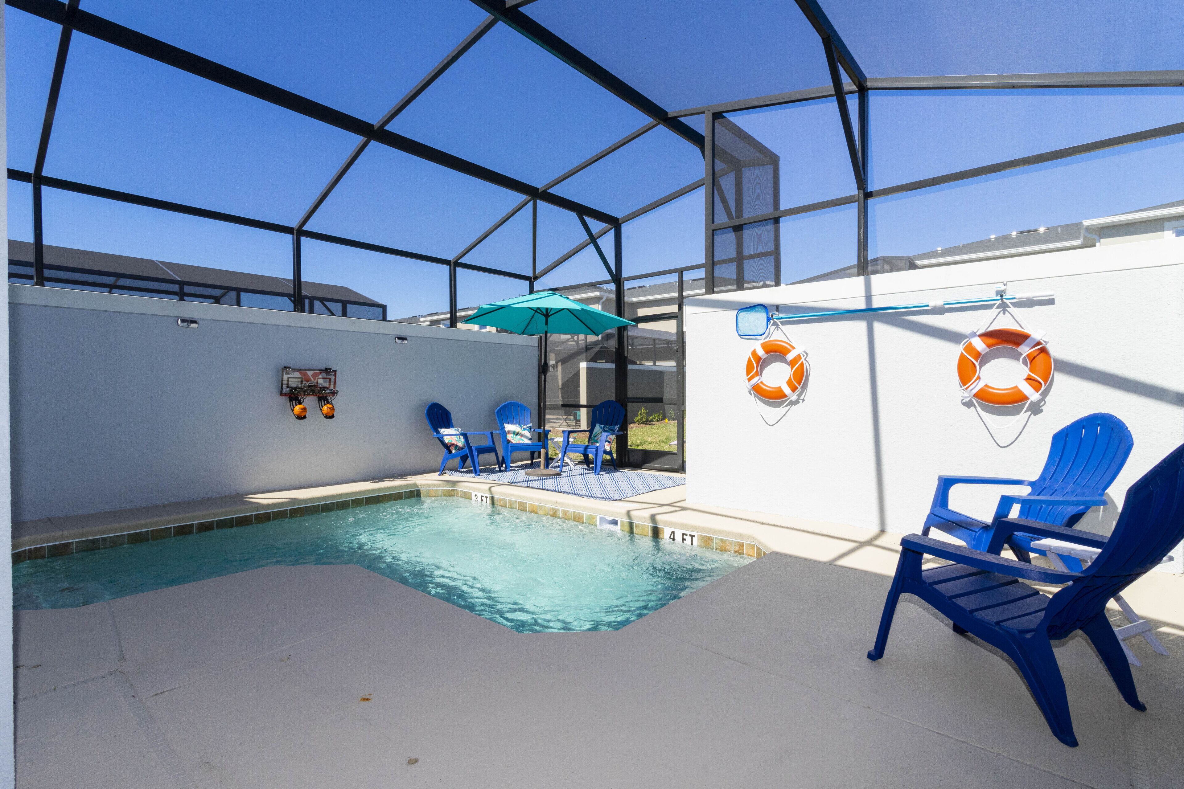An indoor swimming pool with blue chairs and a lifebuoy on the wall.
