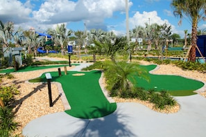 Enjoy a diverse golfing experience amidst lush green areas and tropical plants.