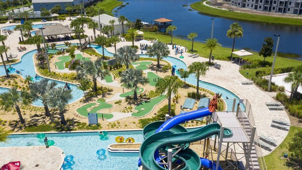 A water park with a large pool, multiple slides, and a golf course.