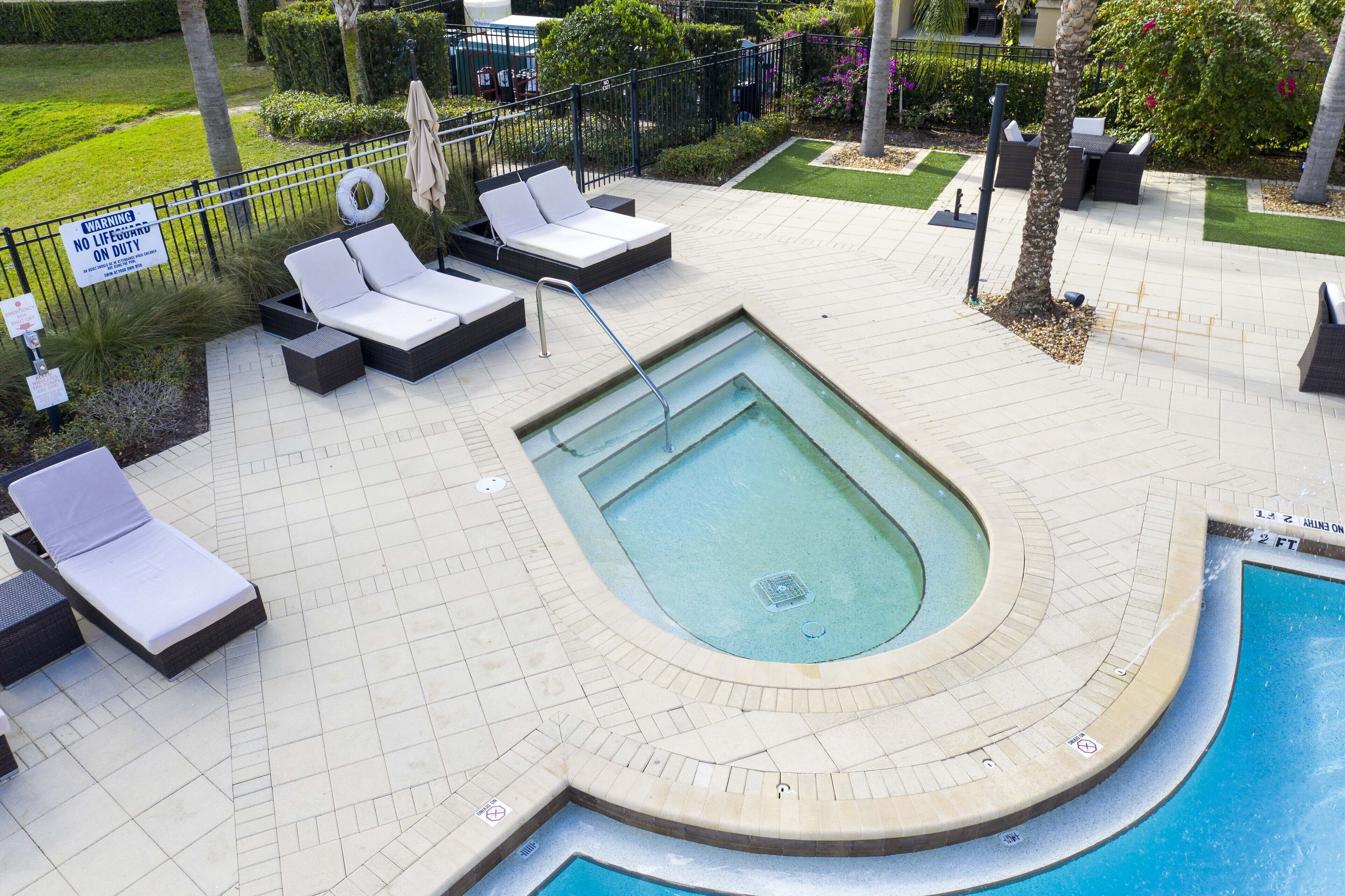Zona de piscina con sillas de descanso y una piscina pequeña.