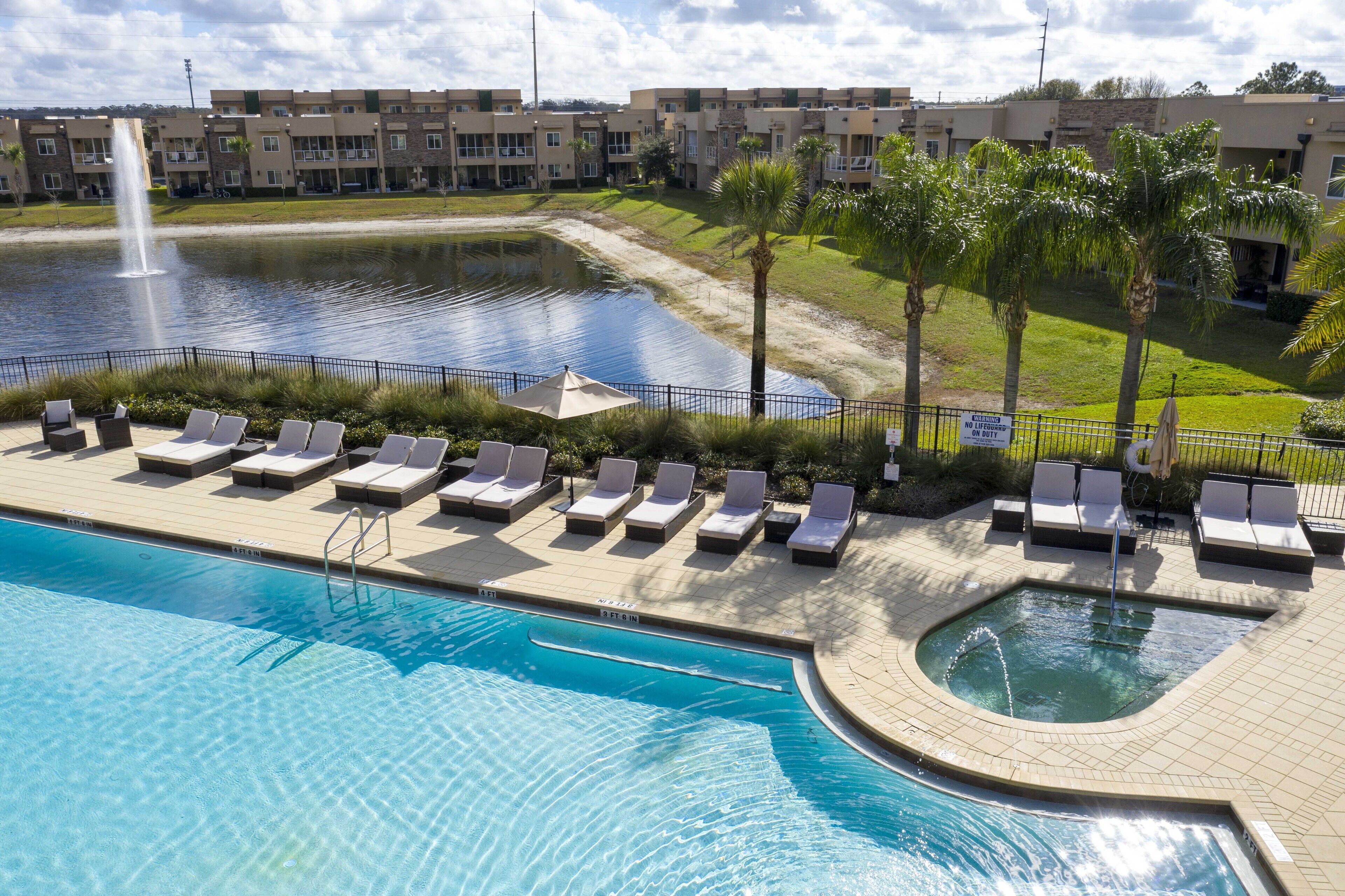 A swimming pool with lounge chairs and a fountain.
