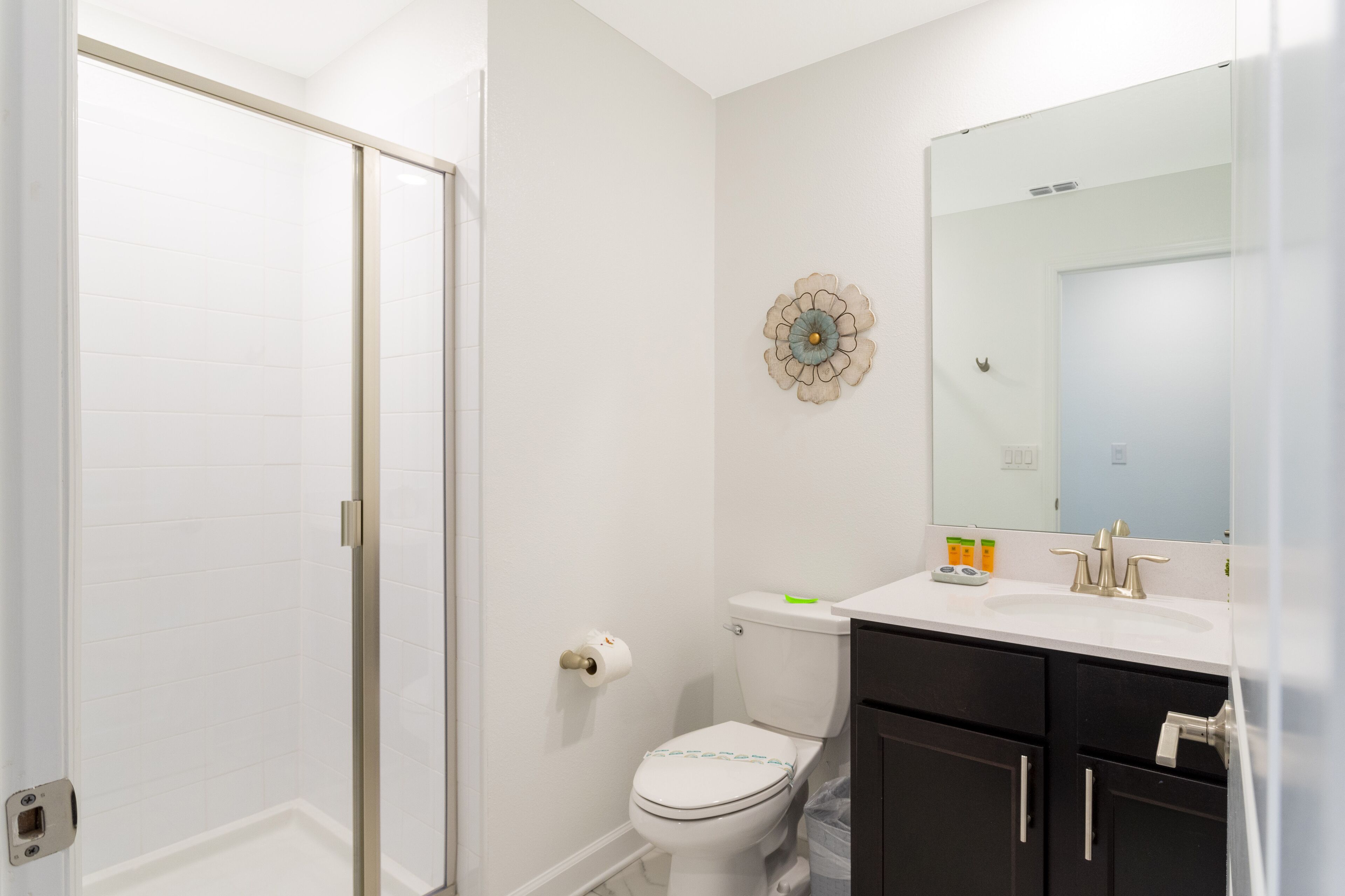 A bathroom with a toilet, sink, and mirror.