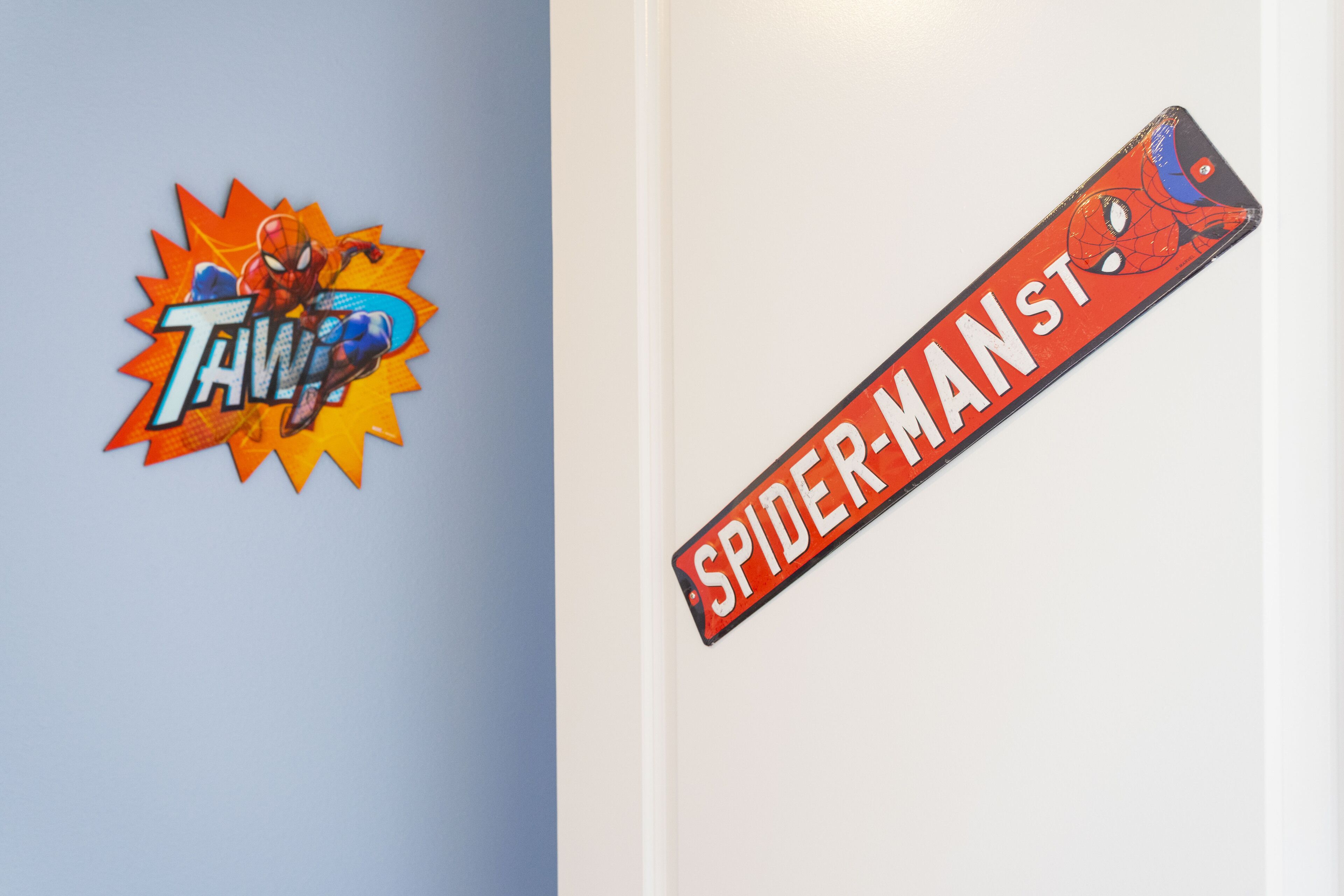 Dos adhesivos para pared, uno con un personaje de superhéroe y otro con una araña.