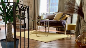 Una escalera de madera conduce a una sala de estar con un sofá, una mesa de centro y una planta en maceta.