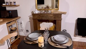 Una mesa para comer con individuales tejidos, platos y una vela, con un espejo y adornos arriba.