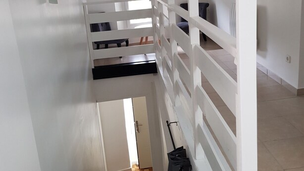 Una escalera con barandillas blancas que sube a un piso superior.