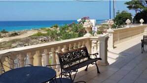 A balcony with a table and bench, overlooking a coastal landscape with the sea and a clear sky. - Villa della Libertà 10 Meters from the Sea, 10/12 SEATS, TORRE SUDA, Gallipoli (Torre Suda)