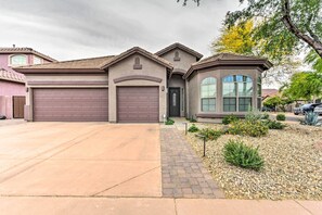 A residential house with a garage, driveway, and landscaped garden. - Private Pool & Hot Tub: Family Home in Phoenix! (Phoenix)