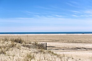 A sandy beach with a wooden fence and sparse vegetation. - 1 Block to Convention Center! Dog-Friendly Apt (Wildwood)