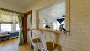 A wooden interior with two white metal chairs, a wooden counter, and a large mirror. - Near Convention Center & Boardwalk! Apt w/ Sunroom (Wildwood)