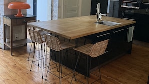 A modern kitchen with a wooden island, black cabinets, and a built-in oven. - Charming town house with pool and garden (Périgueux)